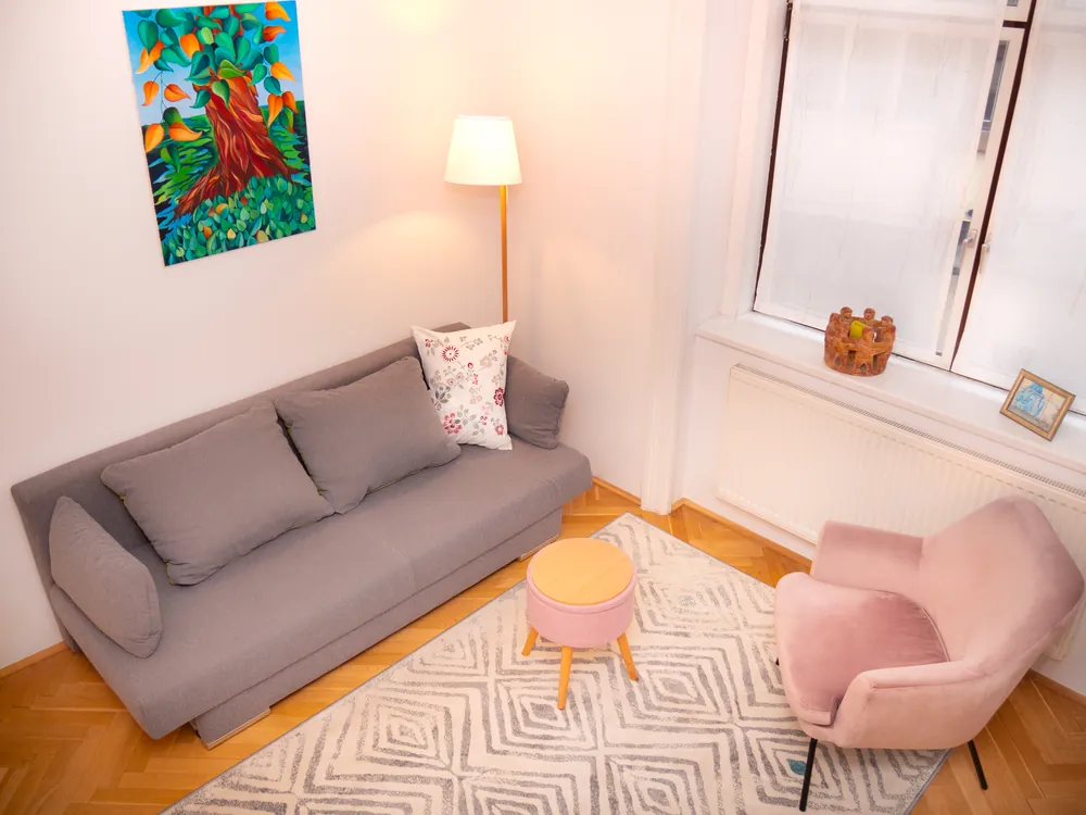 Der Beratungsraum mit Sofa, Leselampe und einem gemalten Baum an der Wand